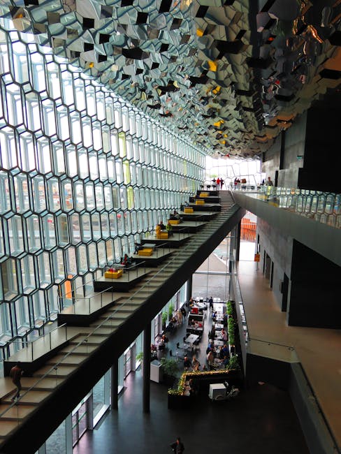 Wide angle view of a futuristic indoor space with glass geometric patterns and multiple levels.